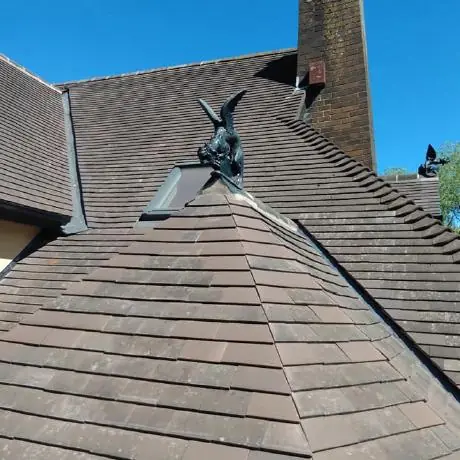 Roofing in Orrell: ornamental finial and chimney on a re-tiled hip roof