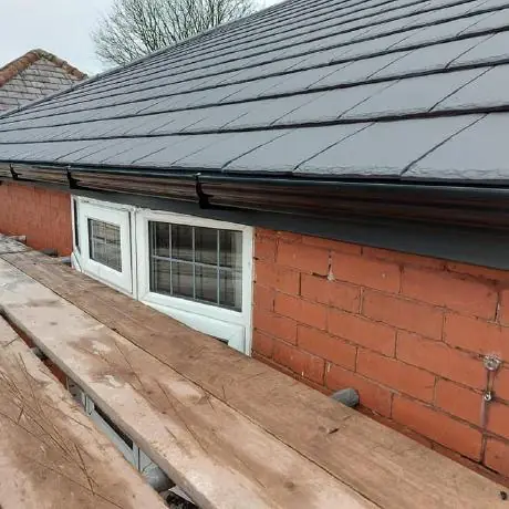 Roofing in Westhoughton: newly tiled grey roof on a brick bungalow
