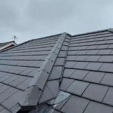 Roofing near Ashton-in-Makerfield: freshly fitted ridge tiles on a grey tiled roof